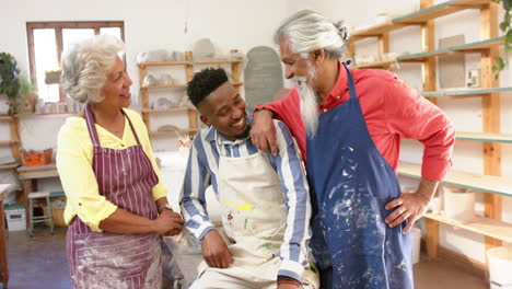 un grupo feliz y diverso de alfareros sonriendo en el estudio de cerámica