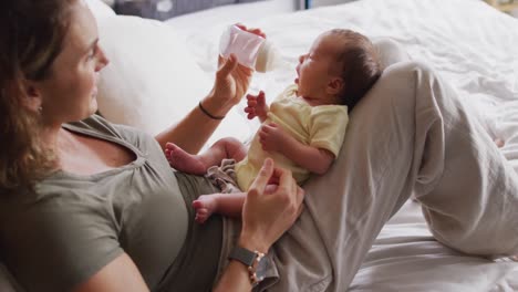 Video-De-Una-Feliz-Madre-Caucásica-Alimentando-A-Un-Bebé-Recién-Nacido-Con-Biberón-En-La-Cama