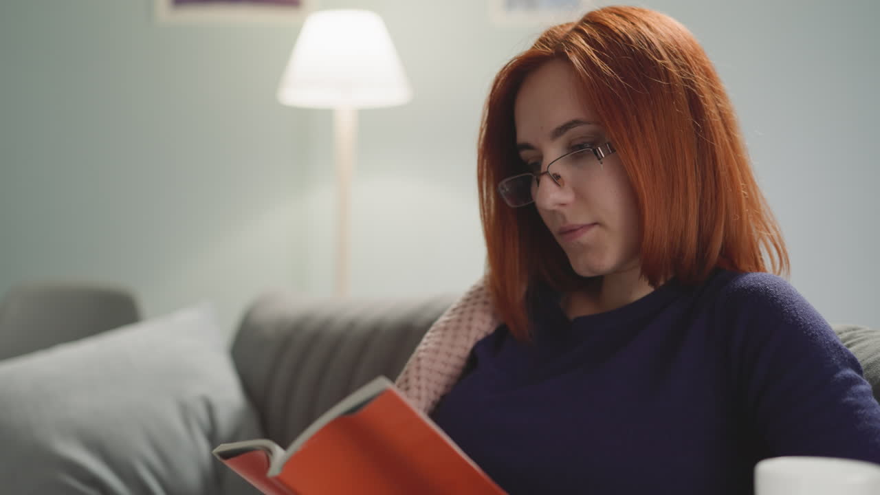 Woman with ginger hair enjoys reading detective story