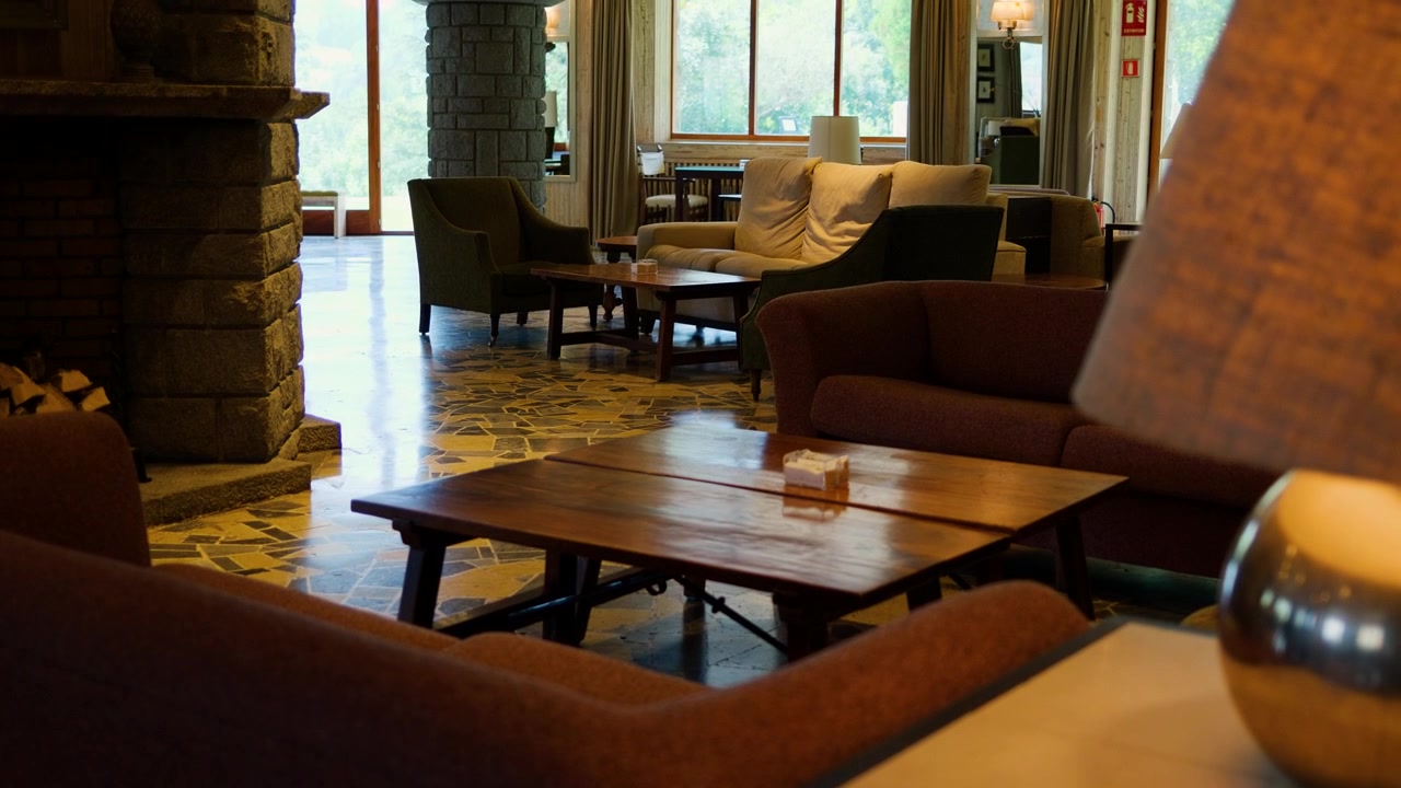 Cozy lounge with soft seating and warm lighting near a large stone fireplace