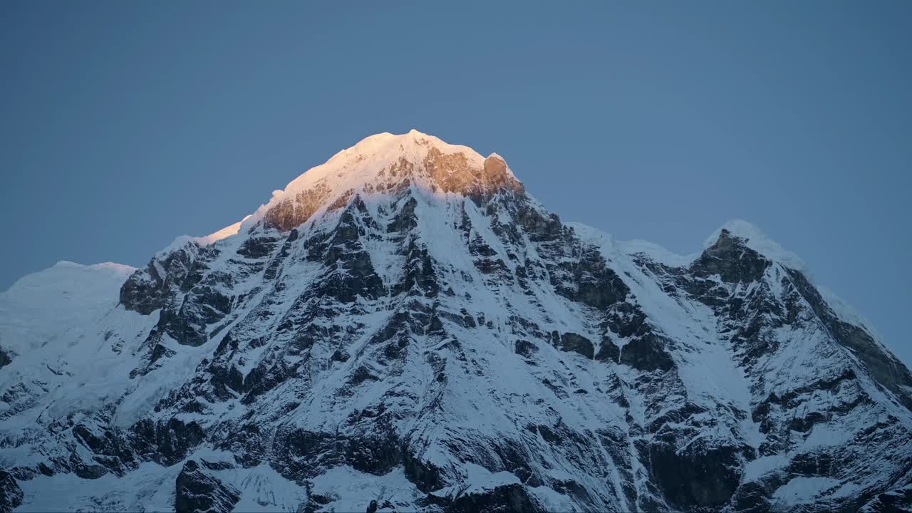 fondo de la cima de la montaña cubierta de nieve con espacio de copia, cresta de montaña de invierno nevada en las montañas del himalaya, fondo azul minimalista del cielo al amanecer en la hermosa primera luz del sol al amanecer