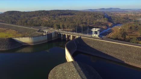 aerial orbit shot of wivenhoe dam, with the stunning brisbane valley in the background, on a clear winter's morning