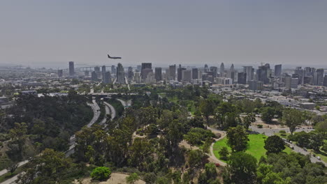 San-Diego-California-Aerial-V73-Panorama-Panning-View-Flyover-Balboa-Park-Aufnahme-Eines-Flugzeugs,-Das-über-Die-Skyline-Der-Stadtmitte-Fliegt-Und-Auf-Dem-Flughafen-Landet---Aufgenommen-Mit-Mavic-3-Cine---September-2022