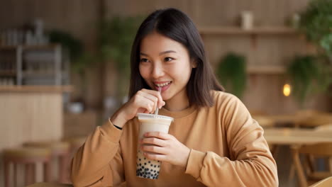 young woman enjoying bubble tea in a cafe