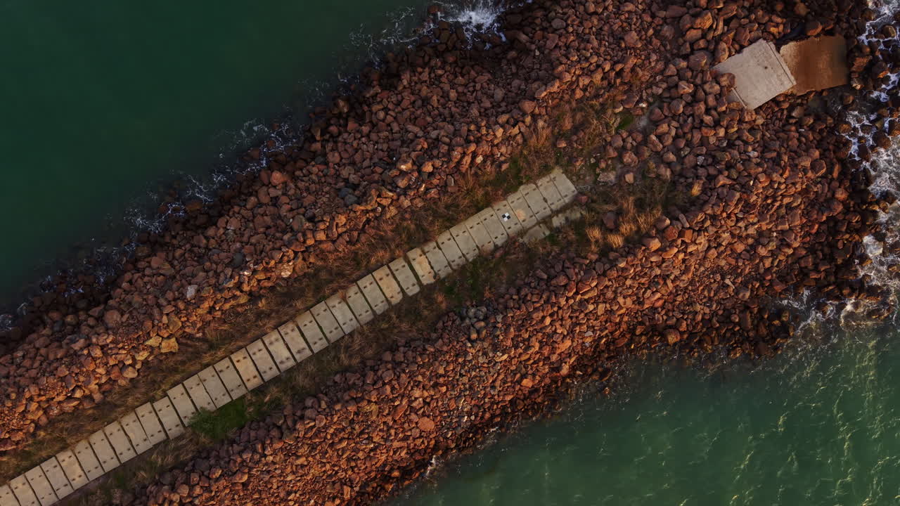 Stones and pathways create a tranquil journey along the water's edge at sunset, inviting exploration and reflection