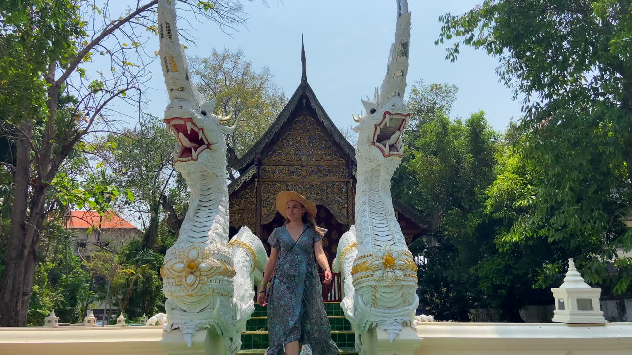 mulher loira alegre visitando o templo de wat chiang man em chiang mai
