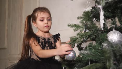 adorable girl decorating christmas tree
