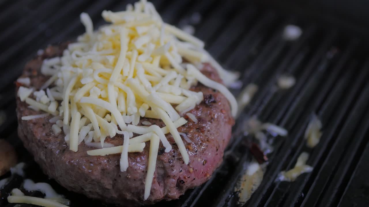 En hakkebøf, der steger ved middelhøj varme på en grillpande af støbejern