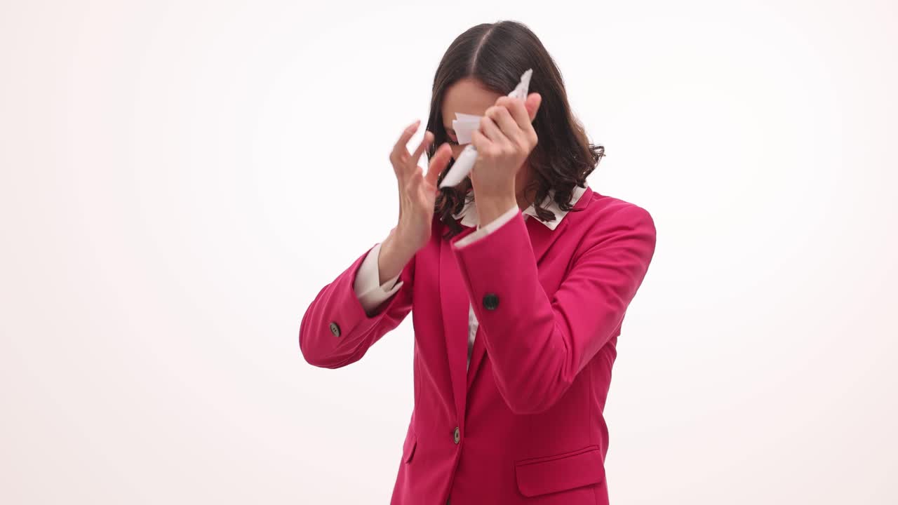 A business woman reacts with frustration and anger to a document, tearing it up in distress