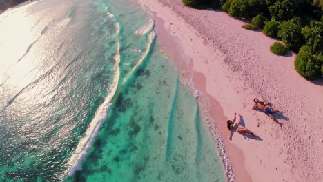 aerial view of a couple relaxing on a tropical beach