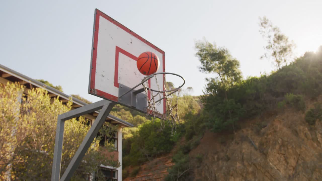 baloncesto cayendo en una canasta en un día soleado