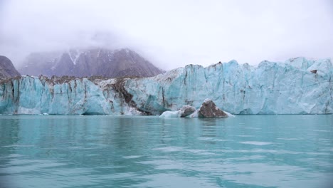glaciar y iceberg en el agua de mar turquesa, alpefjord, groenlandia