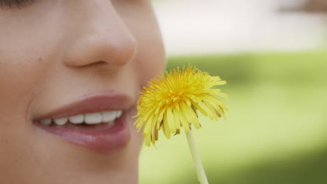woman smelling a dandelion