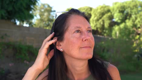 primer plano de mujer de mediana edad con gafas y cabello negro mirando hacia arriba