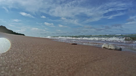 slow motion shot of amazing sea waves crashing over sandy beach on a bright sunny day