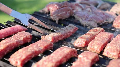 person with fork checking the sausage on the griller