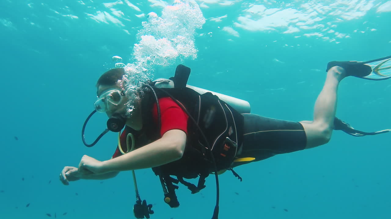 초보자 다이버는 스쿠버 다이빙 장비 1로 수영을 배웁니다.