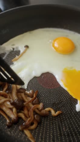 fried eggs with mushrooms in a pan