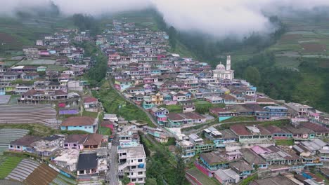 drone vuela sobre una casa rural construida en escalones en la ladera de una montaña