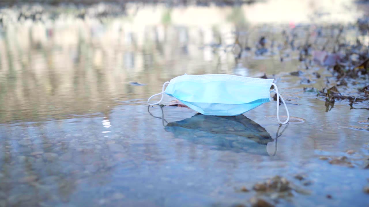 코로나 바이러스 covid-19 전염병 동안 강에 버려진 의료 보호 얼굴 마스크, 물 위에 떠있는 자연 오염
