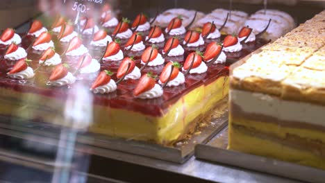 decadent strawberry cake on display in glass case in gourmet dessert shop