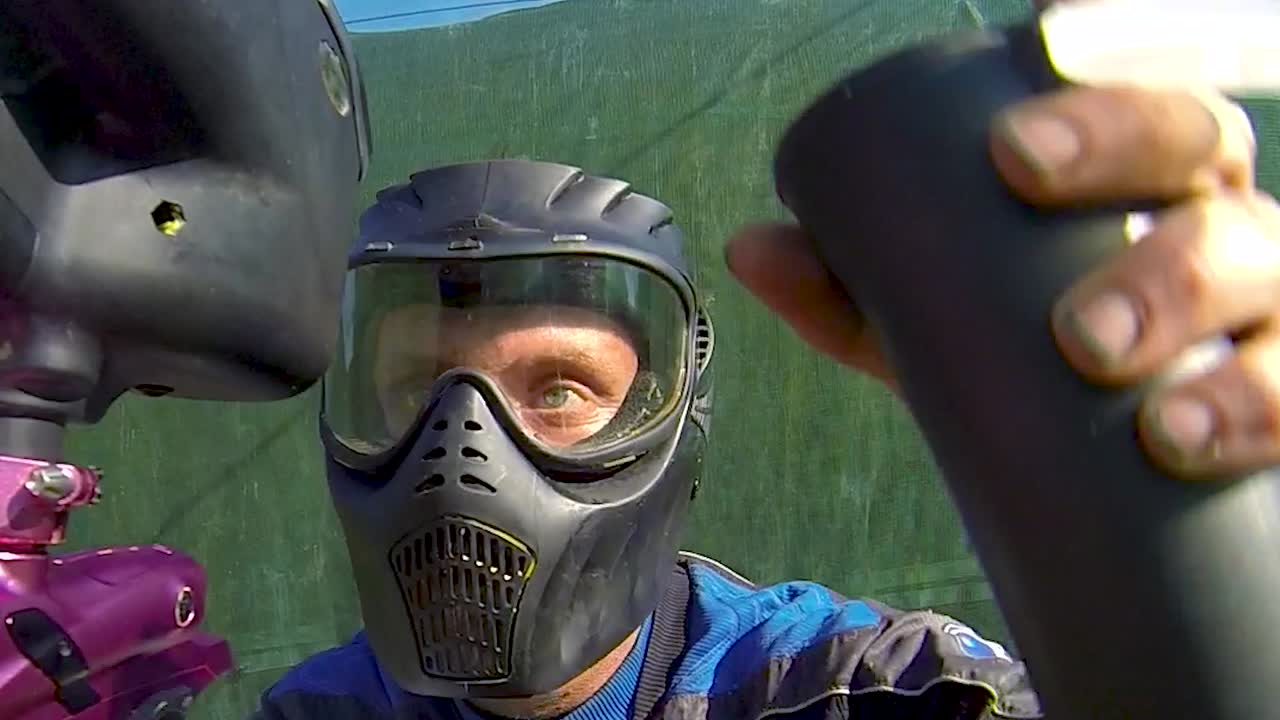 Anak-anak perempuan dan laki-laki bermain paintball di arena luar ruangan-3