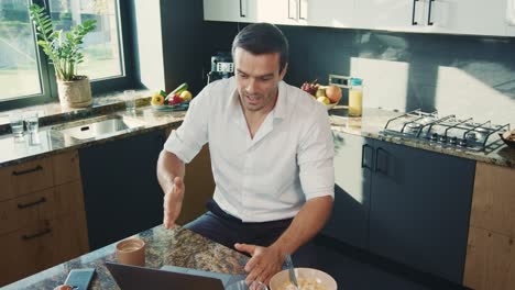 hombre de negocios hablando en la computadora en la cocina. persona sonriente teniendo chat en línea