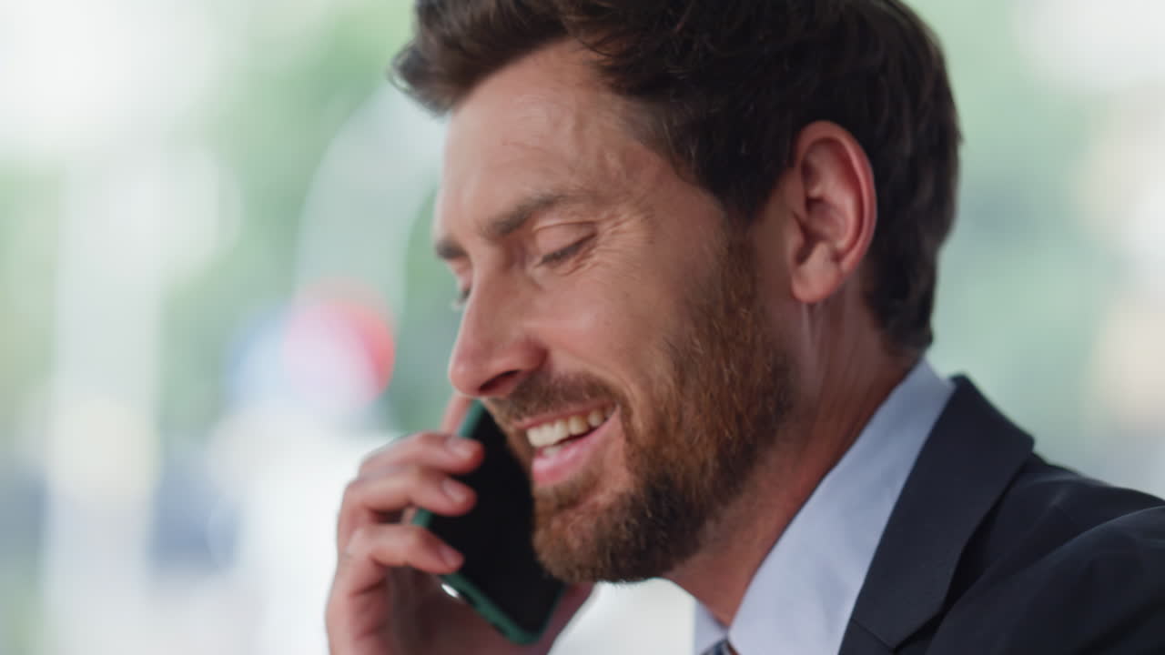 Closeup executive talking cellphone drinking espresso in red cup at cafe
