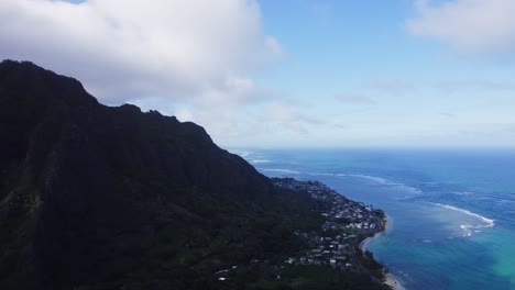 Una-Impresionante-Vista-Aérea-De-La-Costa-De-Oahu,-Con-Exuberantes-Montañas-Verdes-A-Un-Lado-Y-El-Extenso-Océano-Azul-Al-Otro,-Que-Muestra-La-Armonía-De-La-Naturaleza-Y-La-Civilización.