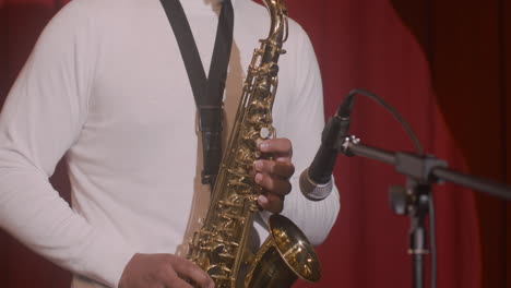 vista de cerca del hombre latino tocando el saxofón durante la actuación de música en vivo 3