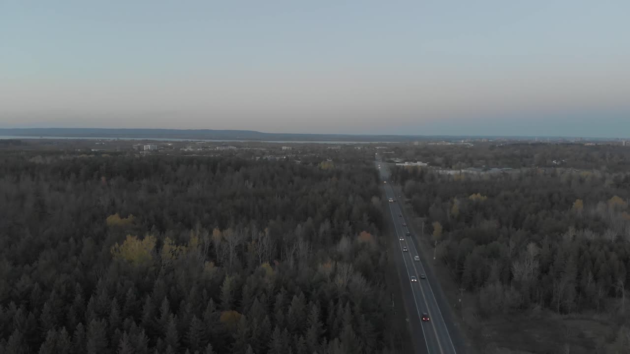 멀리 도시 스카이라인과 푸른 스카이라인이 있는 온타리오주 오타와 바로 외곽의 번잡한 도로 위로 오른쪽으로 이동하는 공중 영상