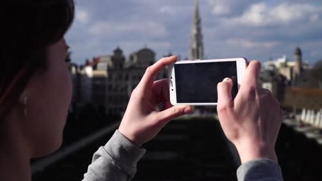 una turista se toma fotos con su teléfono inteligente en bruselas, bélgica.