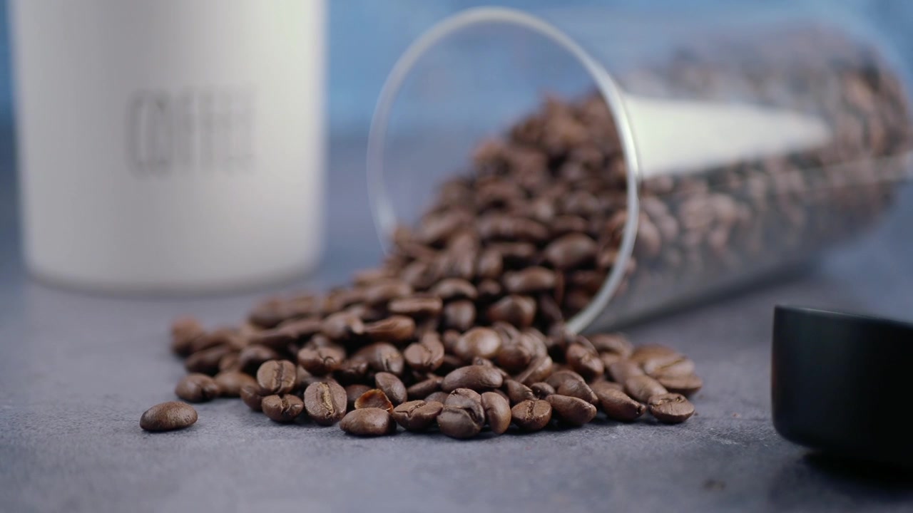 Roasted Coffee Beans Spilled from a Glass Jar on a Table