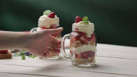 serving no-bake strawberry shortcake trifle in jar