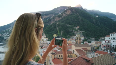 mujer tomando fotos de la costa de amalfi