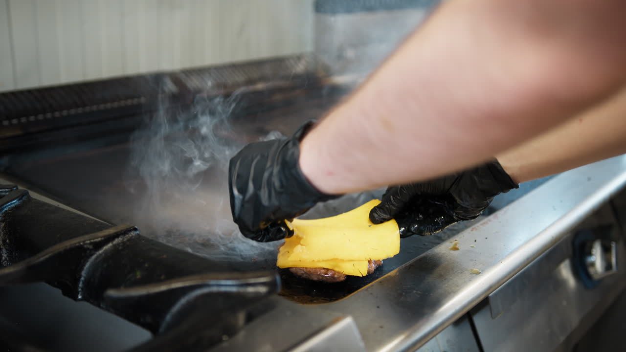 Chef Putting Cheddar On Top Of The Cooking Meat On The Griddle