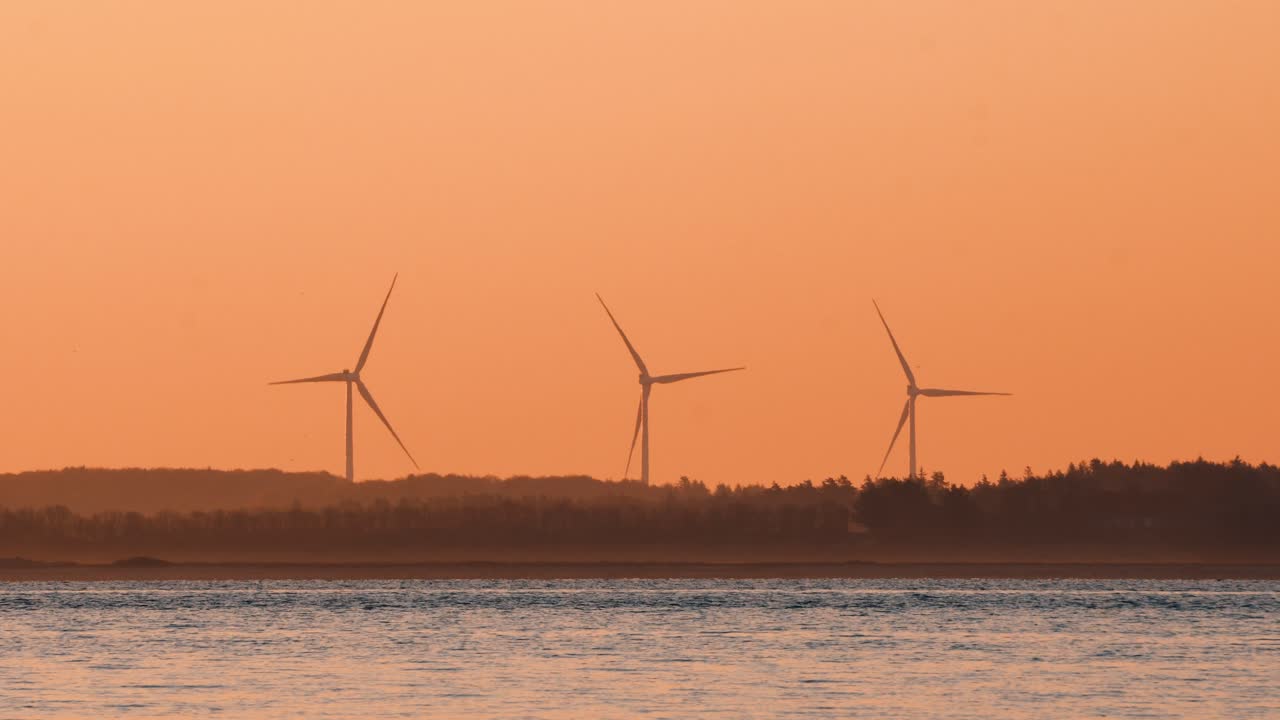 전경에 바다가 있는 육지의 풍차 발전