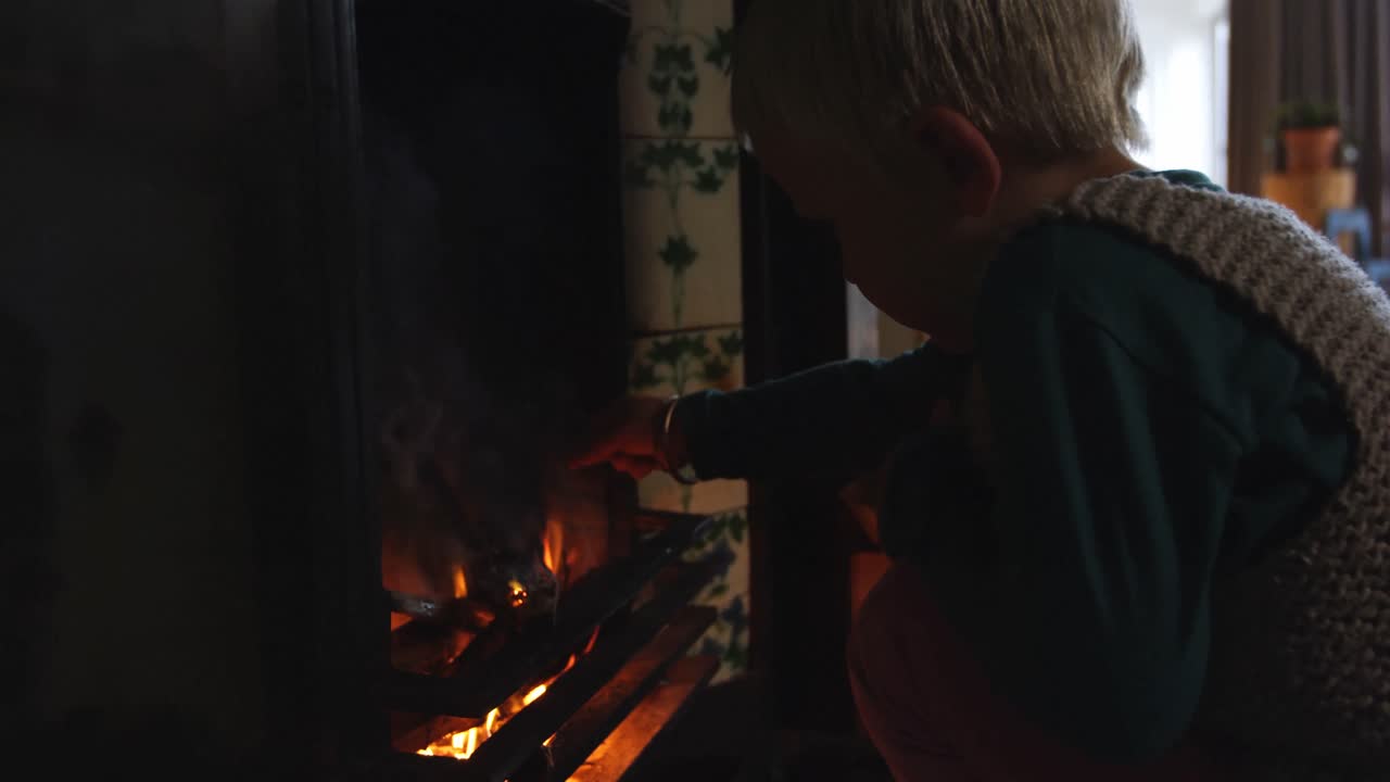집 에서 벽난로 근처 에 앉아 있는 소년 4k
