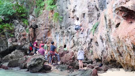 tourists and kids climbing limestone cliffs