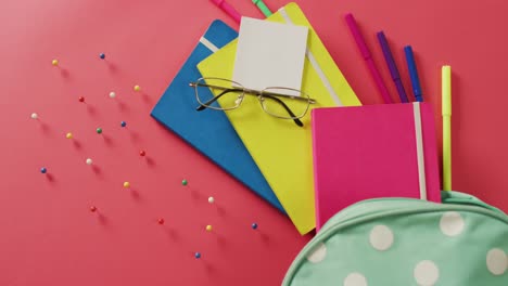 video of composition of school items, glasses and case on pink surface