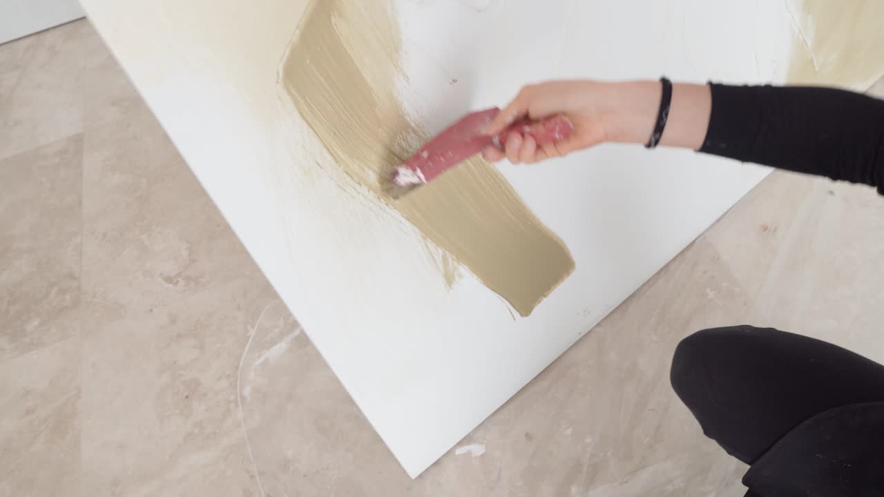 Pittrice professionista che dà colore al suo capolavoro con un grande pennello.