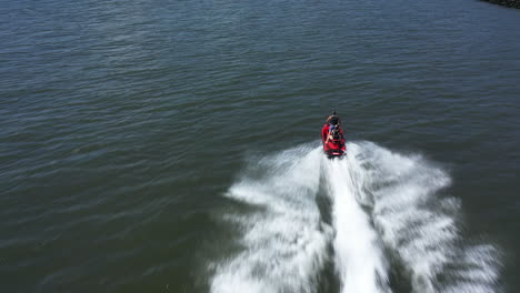 An-aerial-view-of-a-couple-riding-on-a-red-jet-ski