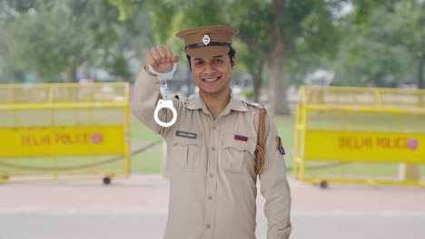 feliz oficial de policía indio posando con esposas