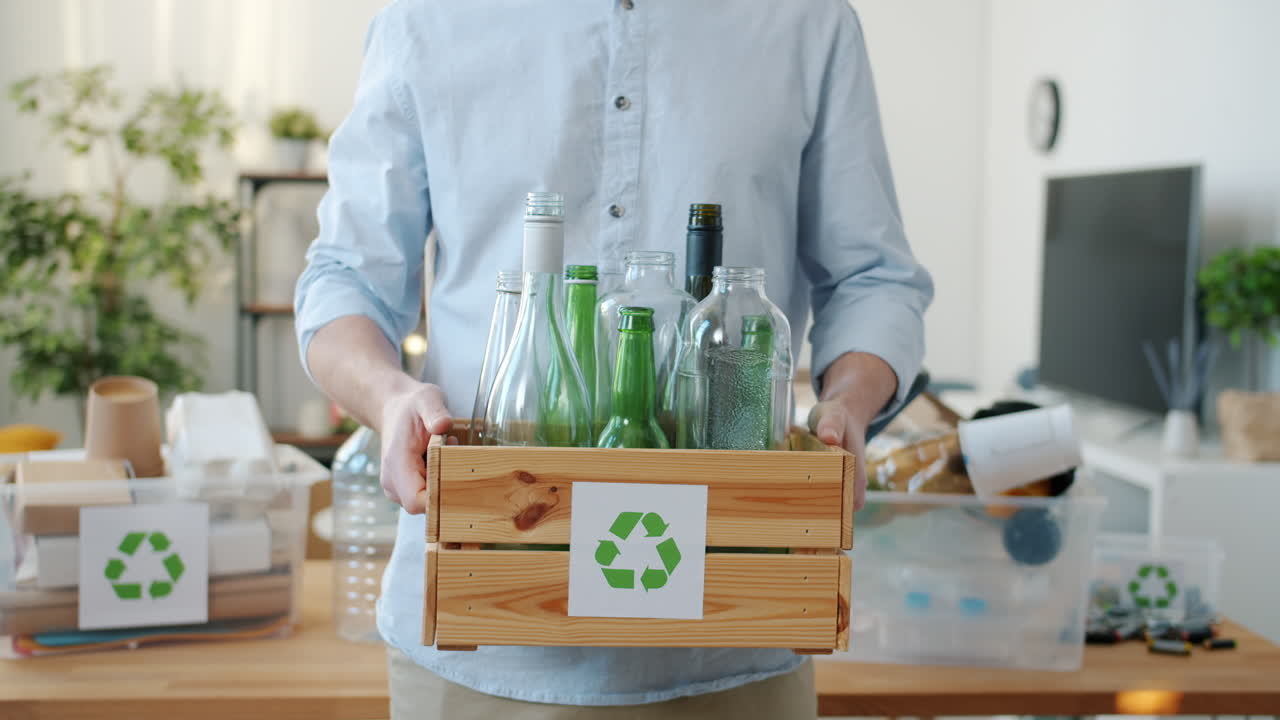 Person Holding a Wooden Crate Full of Recyclable Glass Bottles
