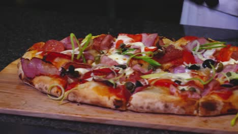el chef preparando una pizza deliciosamente cubierta
