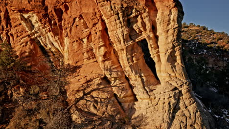 golden hour drone shot unveiling a hidden archway carved by nature near kanab, utah.
