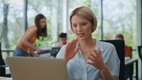 excited lady speaking laptop call at open space closeup. gesturing woman talking