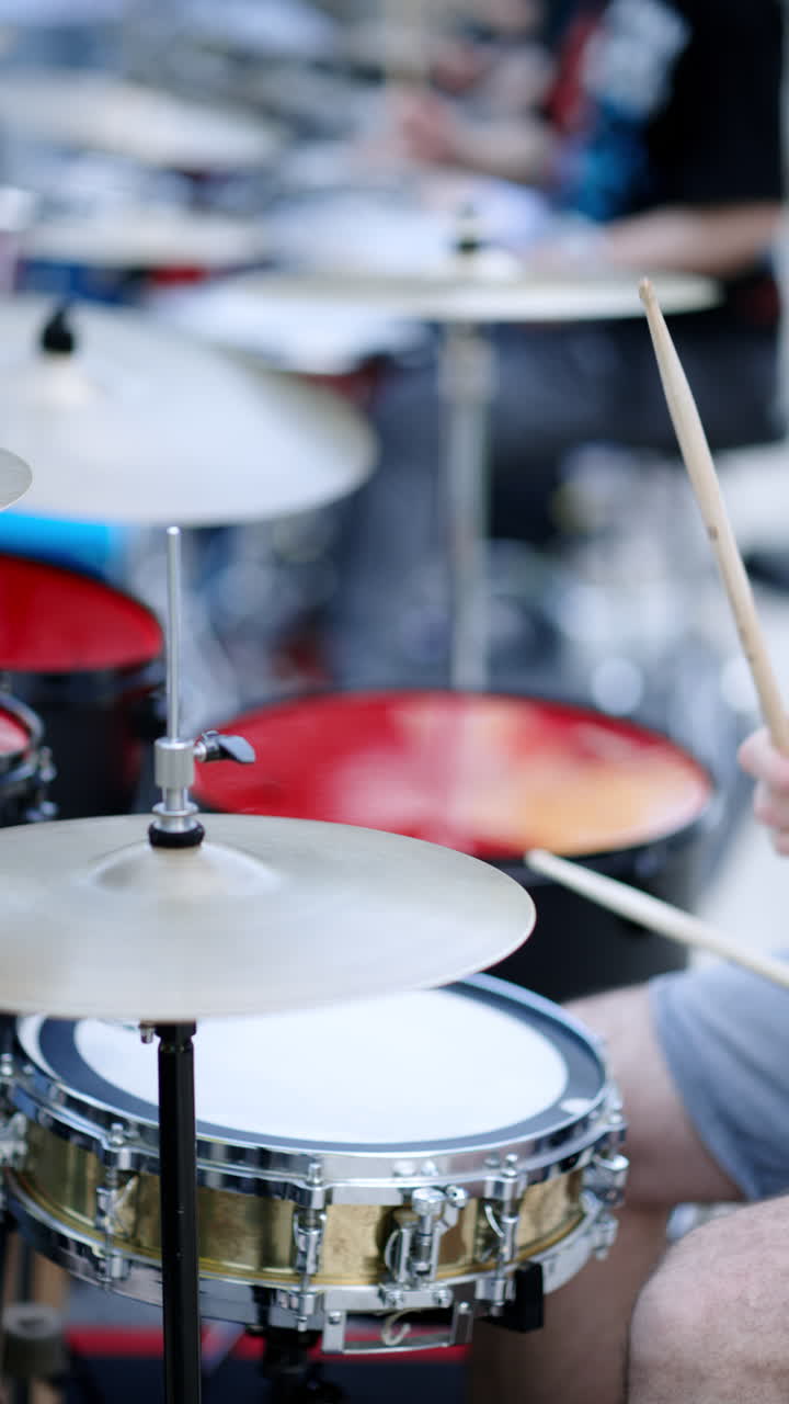Close up of man playing the drums outside. Vertical
