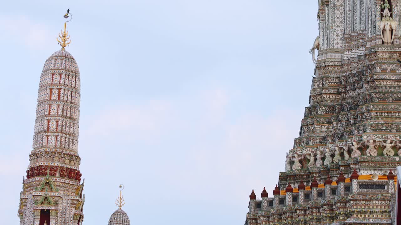 Wat Arun's ornate spires captured in daylight, showcasing intricate architecture and serene atmosphere in Bangkok, Thailand