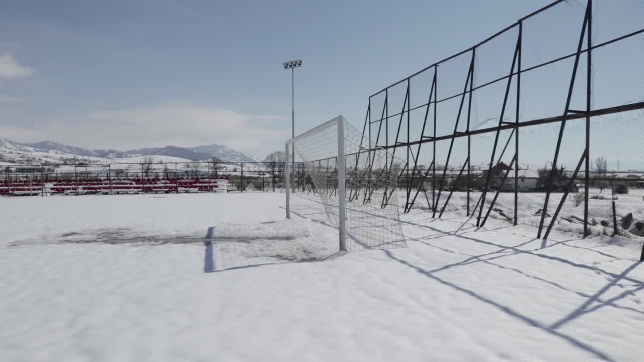 Soccer goal on a stadium covered in snow. Soccer field in winter.